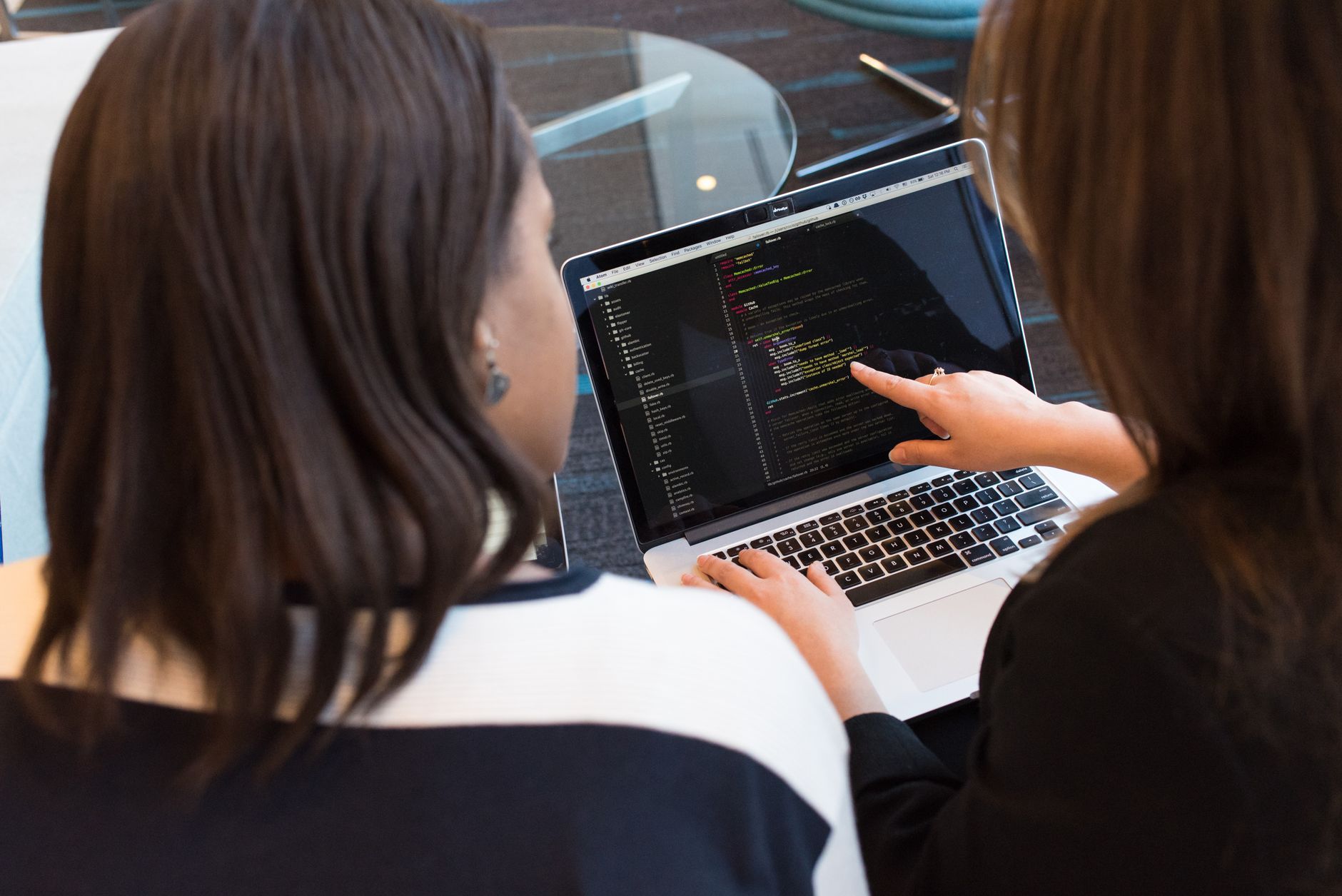 Dwie programistki wspólnie pracują nad kodem w biurze
