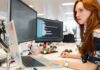 Inżynierka DevOps programuje na dwóch monitorach w nowoczesnym biurze