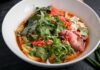 Miska tajskiego czerwonego curry z wołowiną, makaronem i papryczkami chili