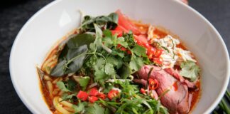Miska tajskiego czerwonego curry z wołowiną, makaronem i papryczkami chili