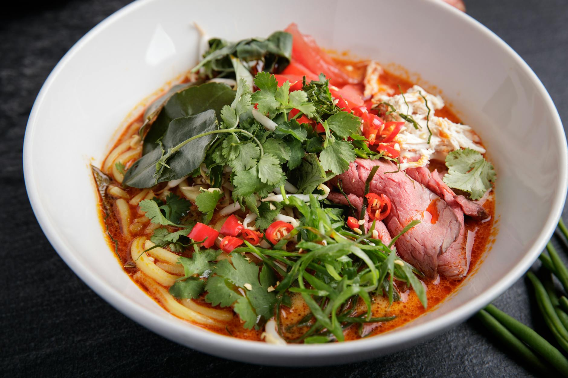 Miska tajskiego czerwonego curry z wołowiną, makaronem i papryczkami chili