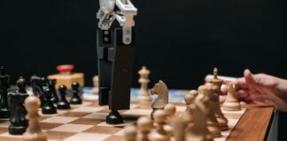 Ramię robota grające w szachy z człowiekiem, symbol rozwoju sztucznej inteligenc