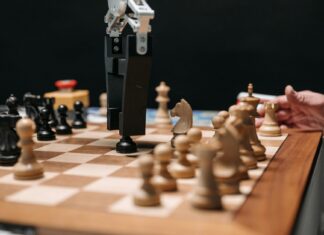 Historia sztucznej inteligencji: od prostych reguł do modeli generatywnych Ramię robota grające w szachy z człowiekiem, symbol rozwoju sztucznej inteligenc
