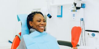 Uśmiechnięta pacjentka z lusterkiem podczas kontroli u dentysty