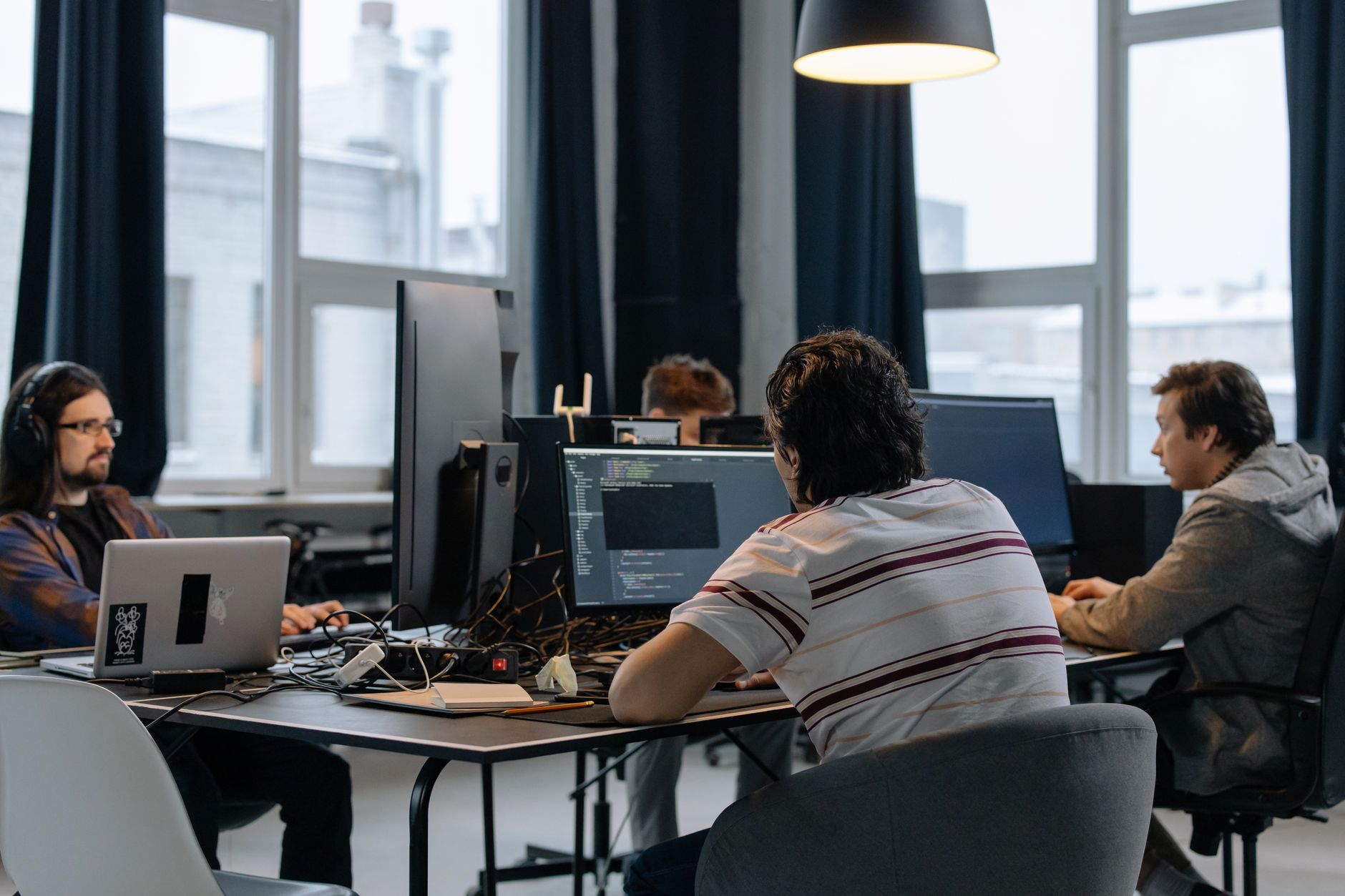 Zespół programistów pracuje razem nad kodem w nowoczesnym biurze startupu