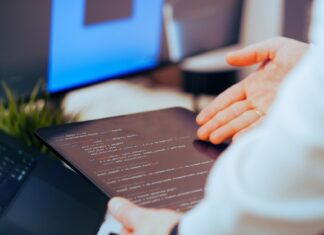 Programista analizujący kod na tablecie w nowoczesnym biurze