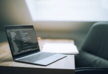 Pierwsze kroki w Git i GitHub dla programistów: praktyczne komendy, workflow i dobre nawyki Otwarty laptop z kodem na biurku w nowoczesnym jasnym biurze