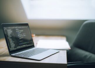 Pierwsze kroki w Git i GitHub dla programistów: praktyczne komendy, workflow i dobre nawyki Otwarty laptop z kodem na biurku w nowoczesnym jasnym biurze