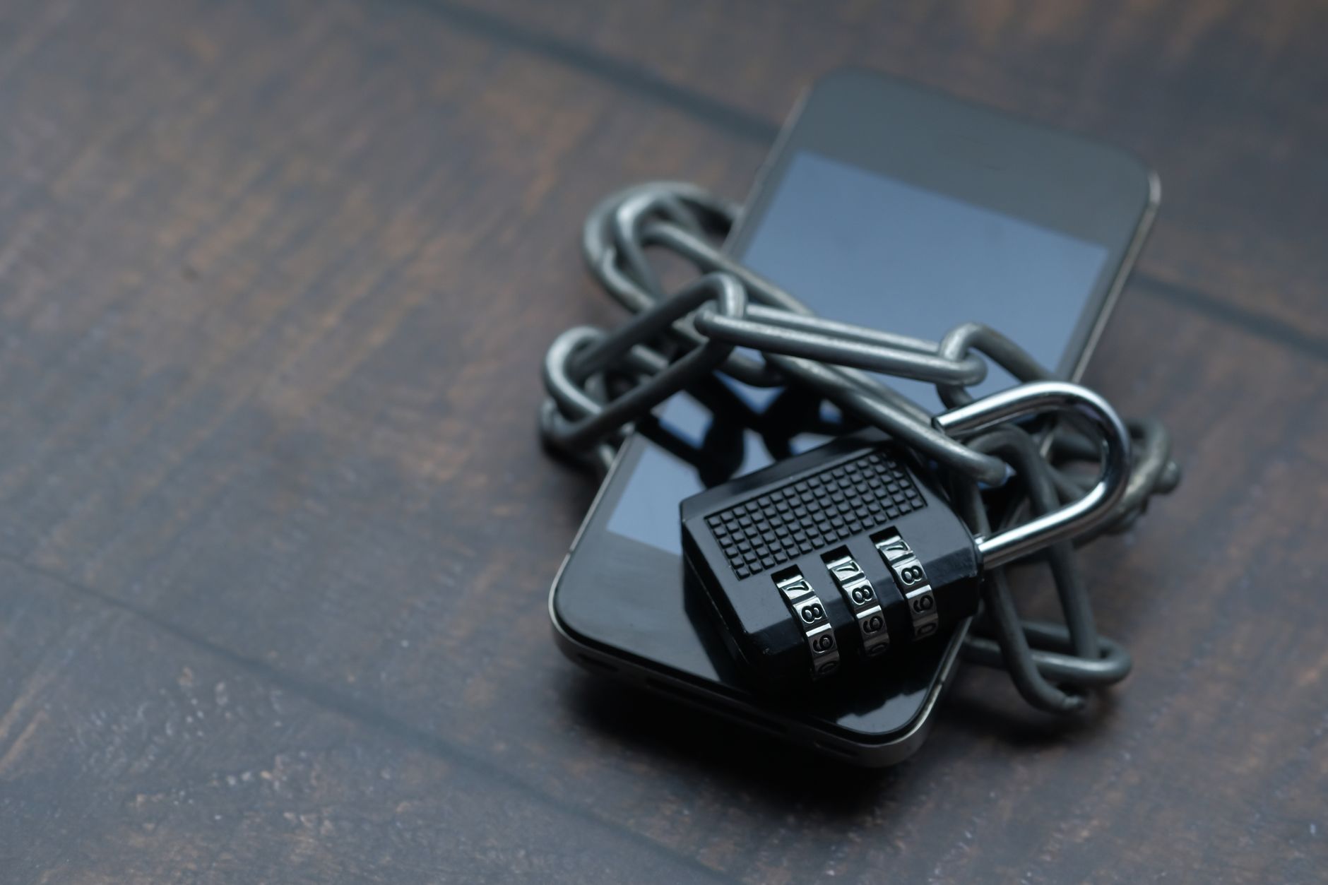 Smartfon owinięty łańcuchem z kłódką symbolizujący ochronę danych Smartfon owinięty łańcuchem z kłódką symbolizujący ochronę danych