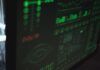 Wykrywanie anomalii z użyciem machine learningu w logach systemowych i sieciowych Zbliżenie na ekran komputera z interfejsem cyberbezpieczeństwa w zieleni