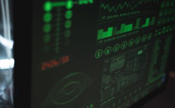 Wykrywanie anomalii z użyciem machine learningu w logach systemowych i sieciowych Zbliżenie na ekran komputera z interfejsem cyberbezpieczeństwa w zieleni